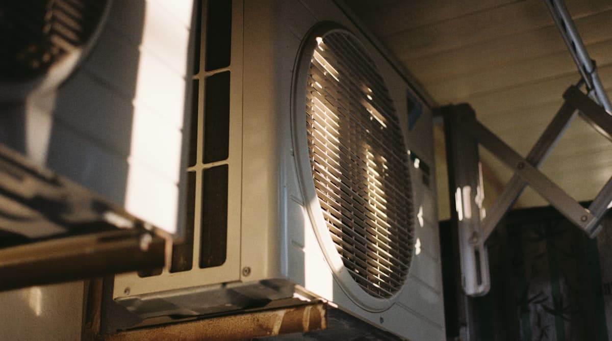 Homeowner checking outdoor AC condenser unit during summer