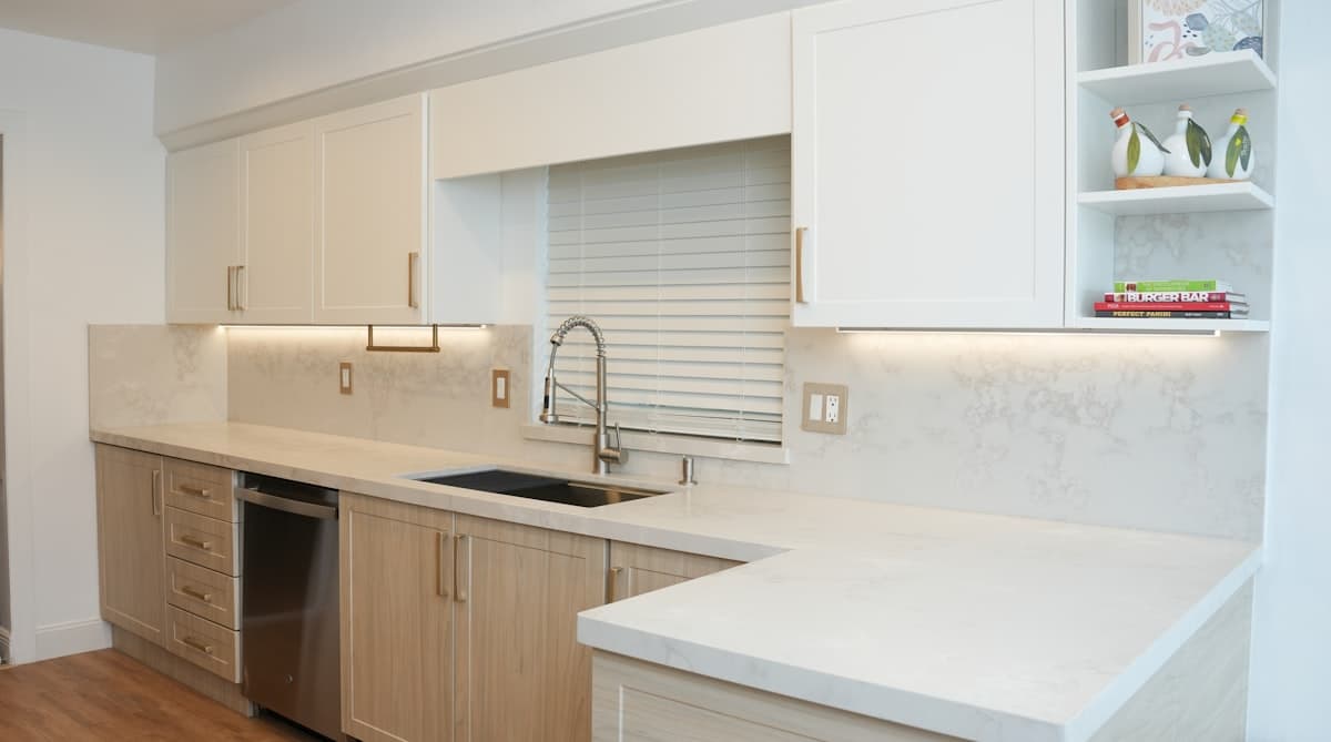 Modern kitchen with white cabinets and granite countertops after renovation